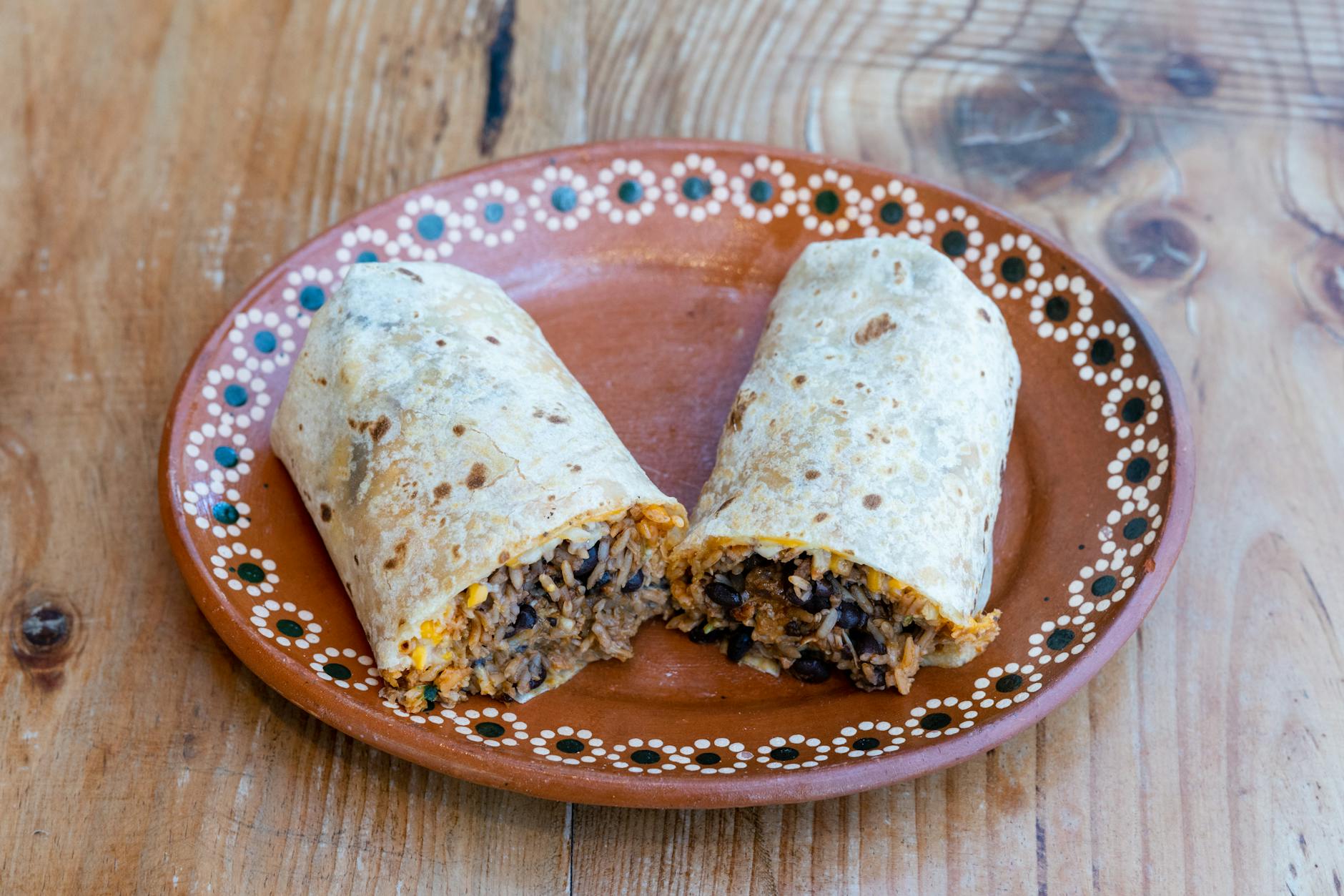 Burrito z ryżem i fasolą na ozdobnym talerzu, lekkie danie meksykańskie