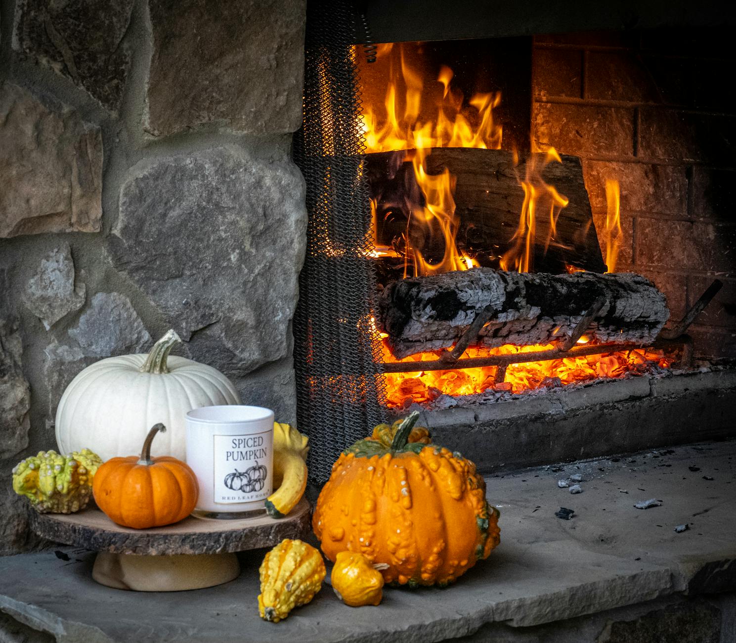 Jesienna aranżacja z dyniami przy rozpalonym kominku