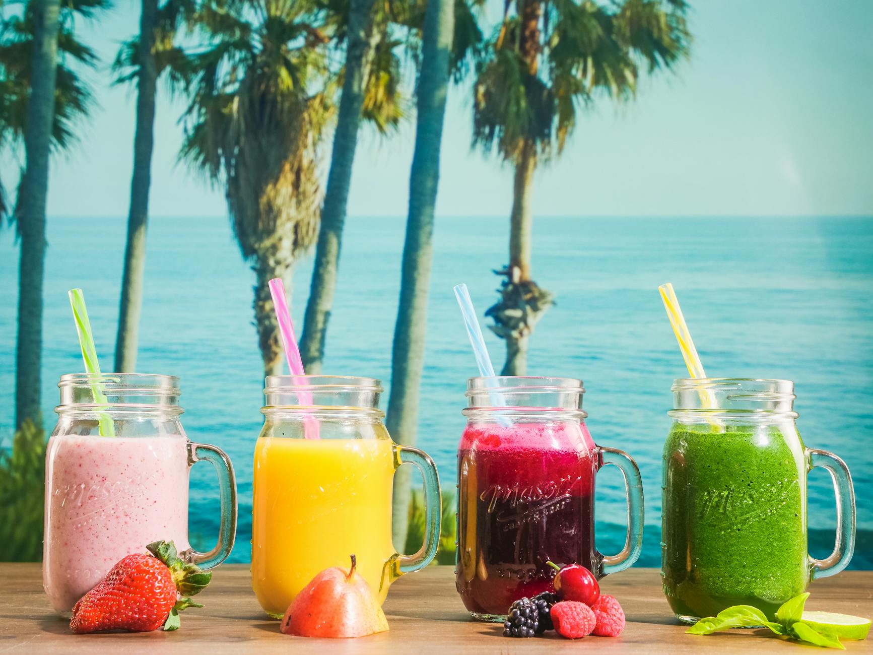 Kolorowe smoothie w słoikach na tle tropikalnego oceanu