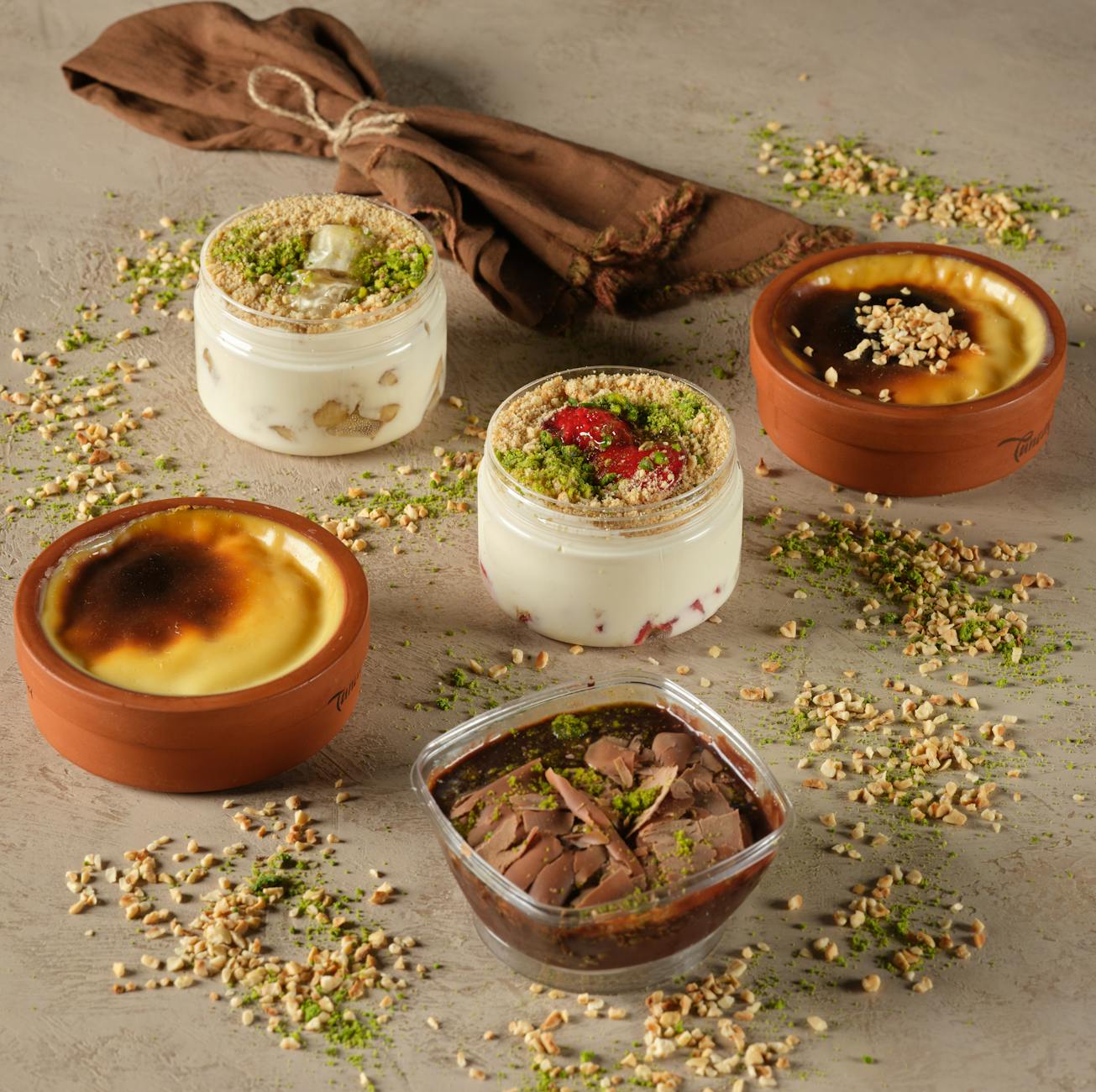 Domowe desery w szkle i ceramice, udekorowane orzechami i ziołami